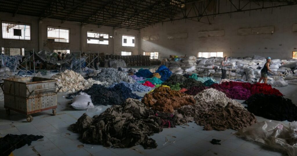 縫製工場で大量に生産され積み上げられた衣服の山